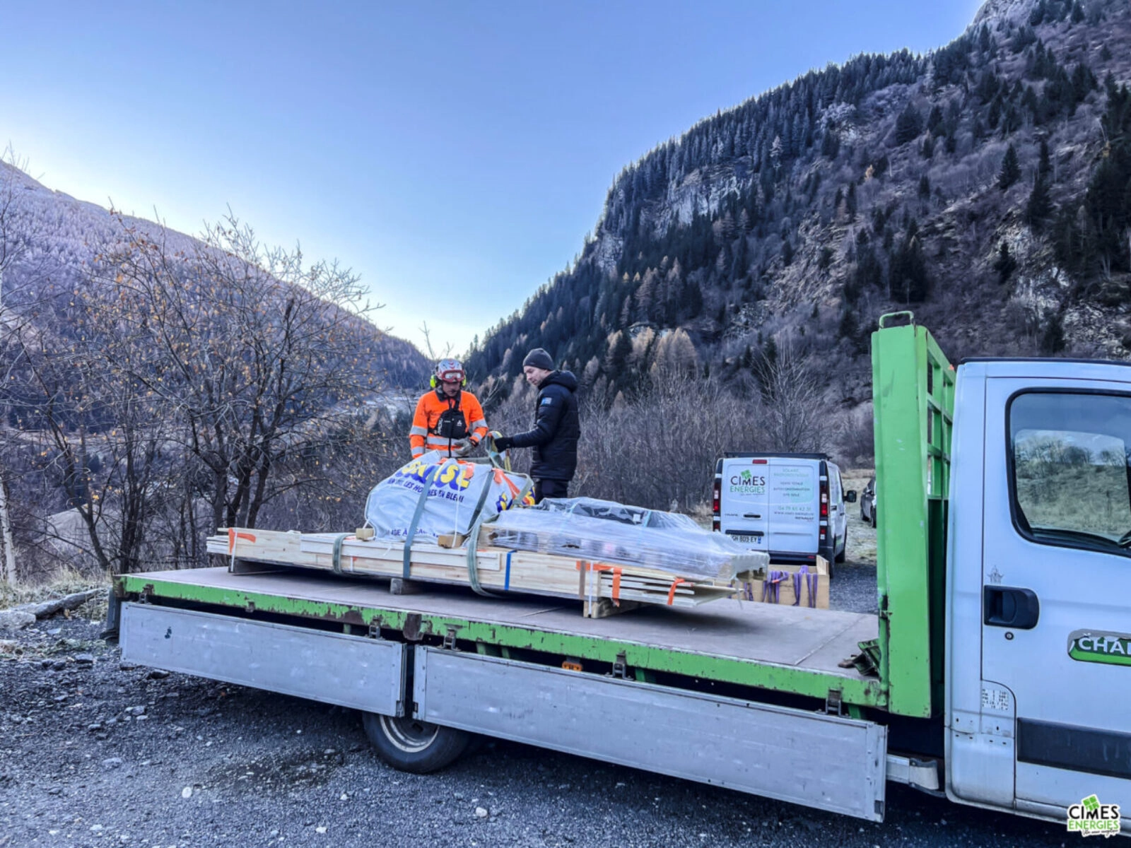 opération de déchargement du matériel solaire et électrique d'un camion de transport, arrière-plan de montagne en automne