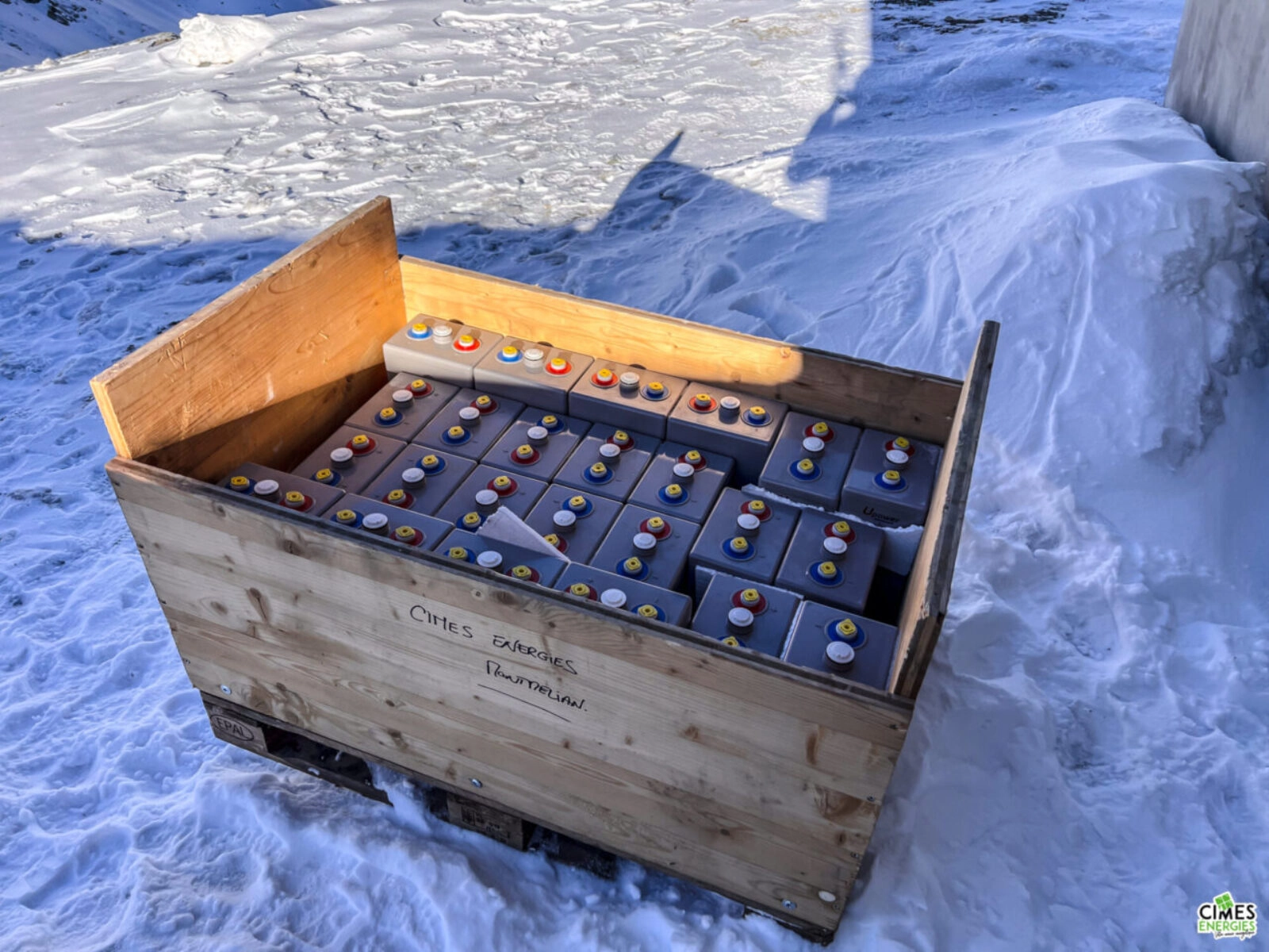 Parc batterie conditionné dans une caisse en bois, posée sur la neige