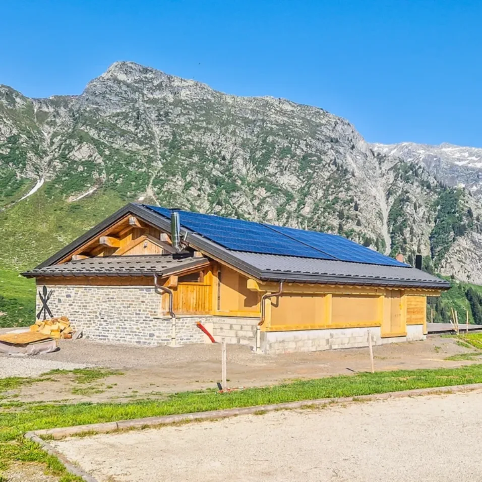 Installation solaire sur restaurant d'altitude à la Rosière, arrière-plan de montagne en été, journée ensoleillée et ciel bleu