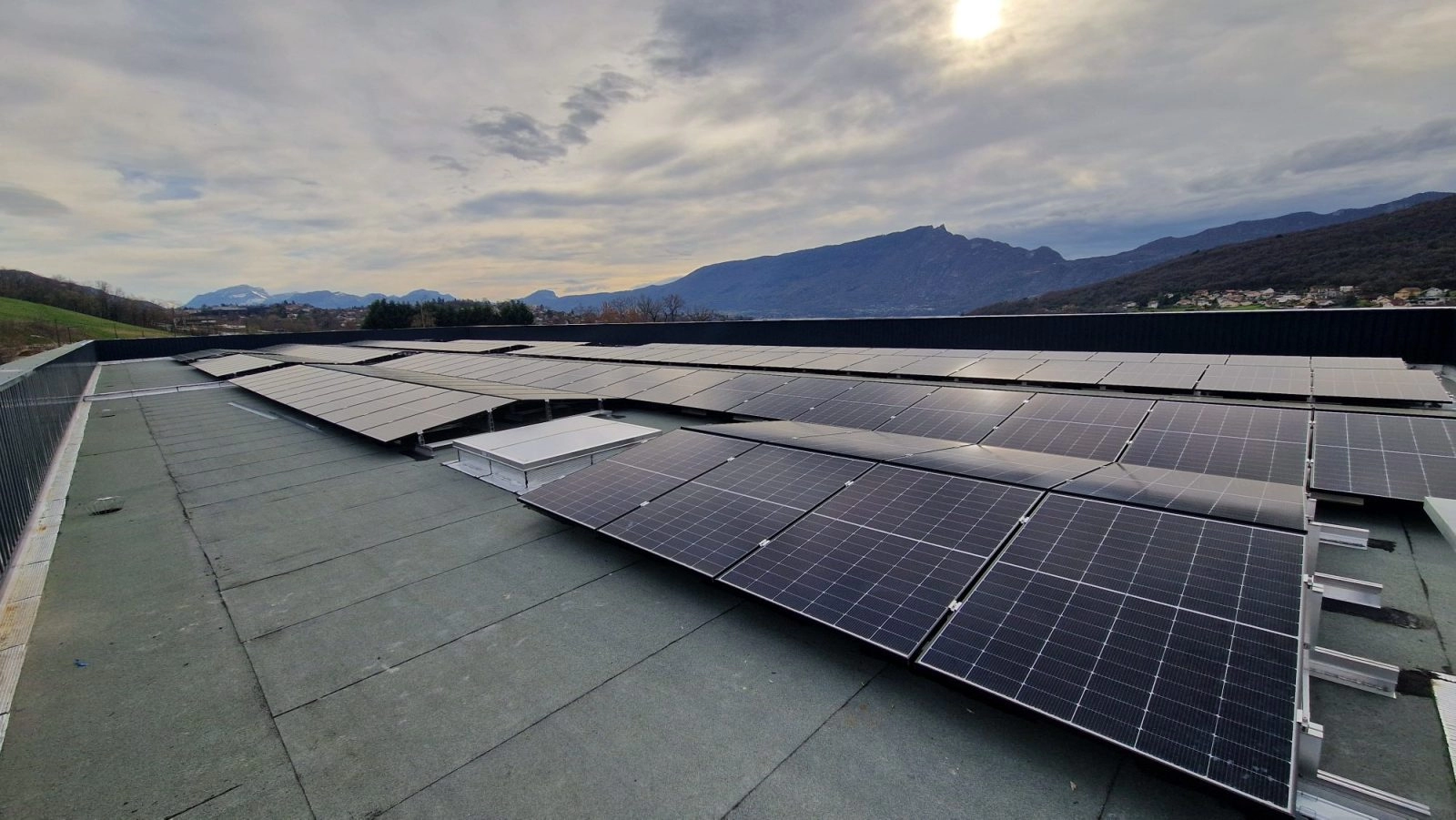 Installation photovoltaïque en autoconsommation collective pour Grolla Verre à Grésy-sur-Aix avec 286 panneaux solaires en toiture terrasse avec la Dent du Chat en arrière-plan