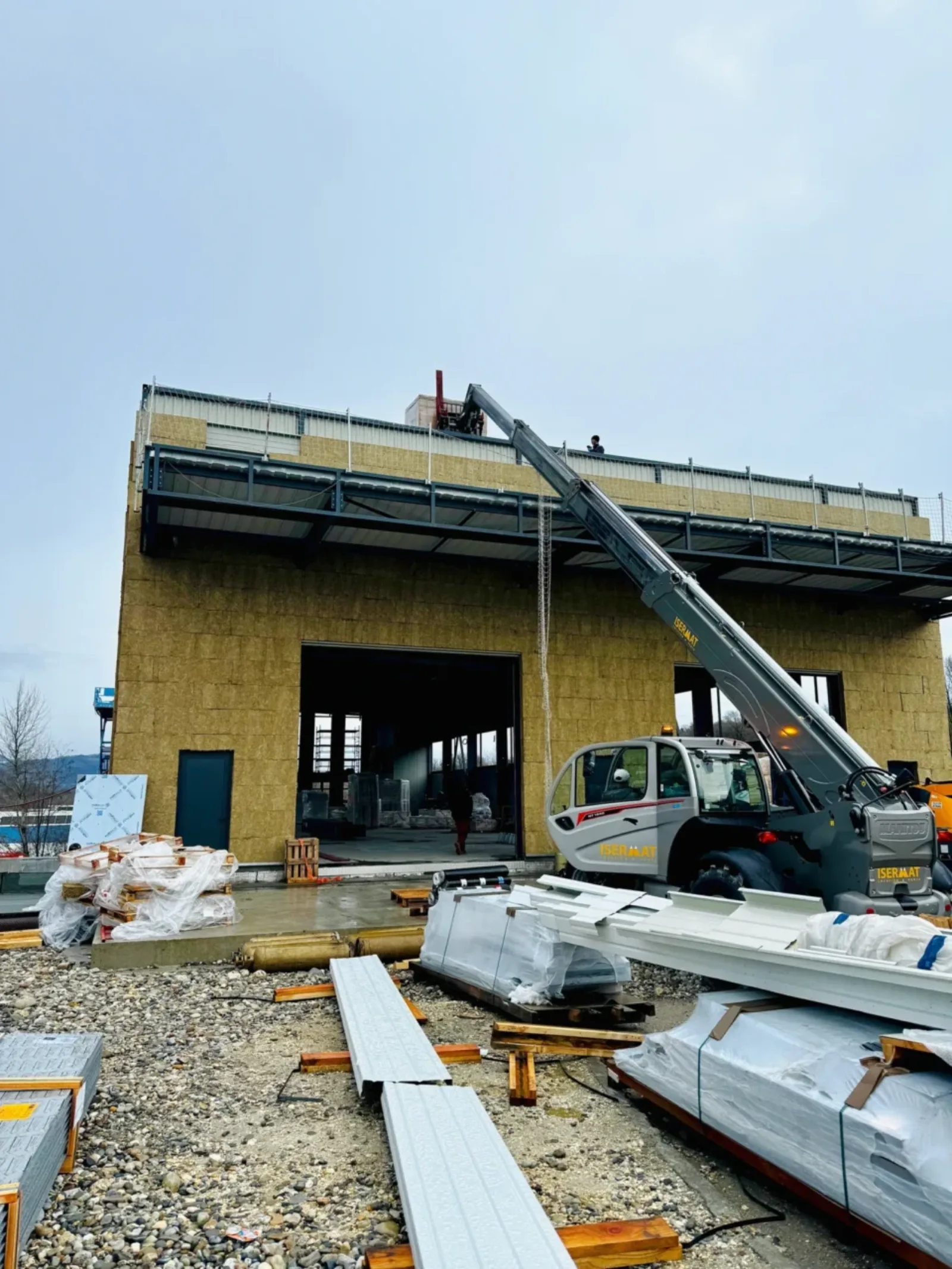 Engin de levage sur un chantier de construction pour monter des panneaux solaires sur le toit