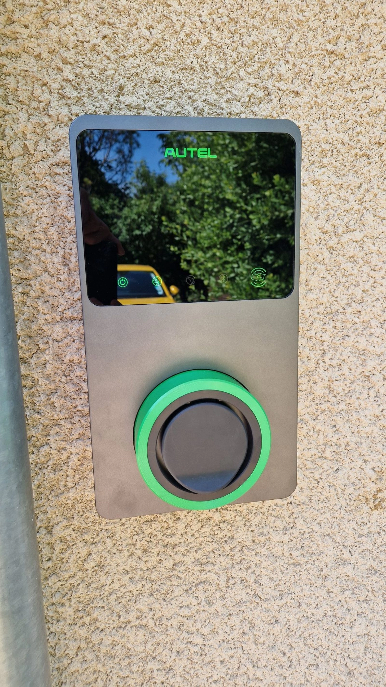 Borne de recharge Autel installée sur mur exrtérieur d'une maison, gros plan
