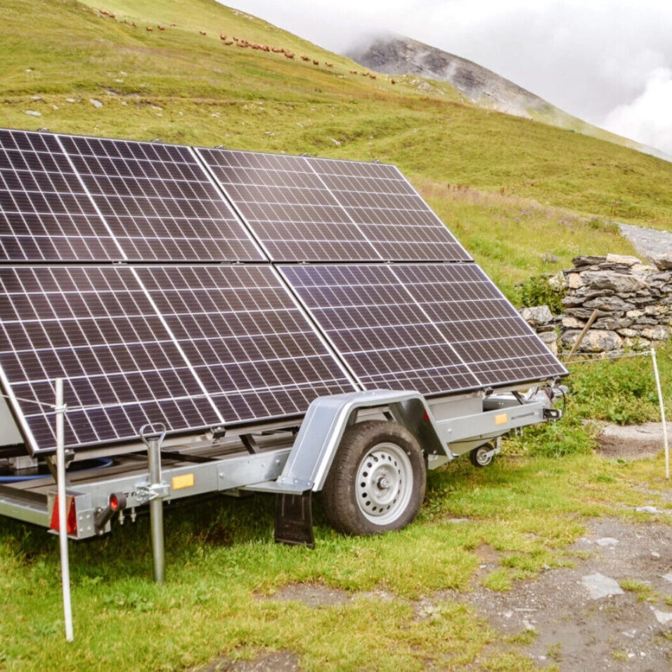 Remorque solaire garée en alpage, arrière-plan de montagne en été, journée partiellement ensoleillée
